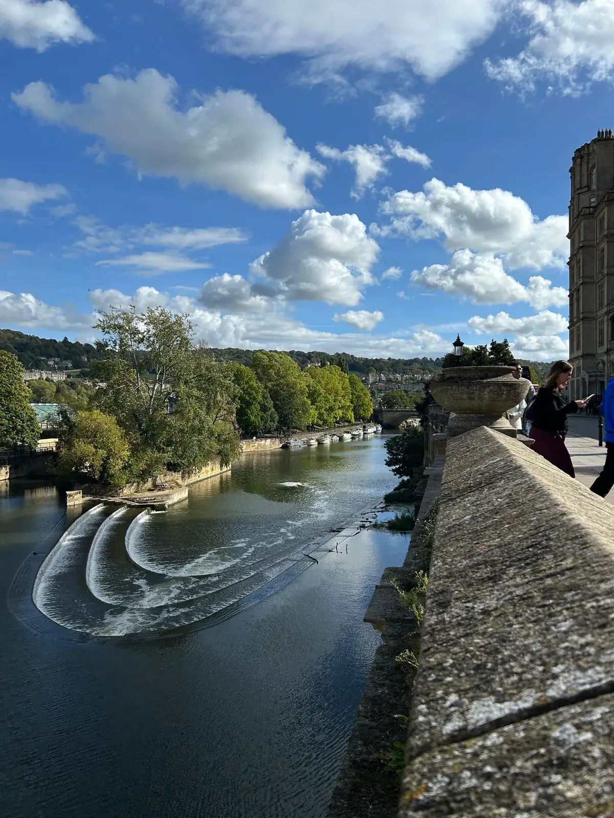 The River Avon, weir and stone buildings in Bath