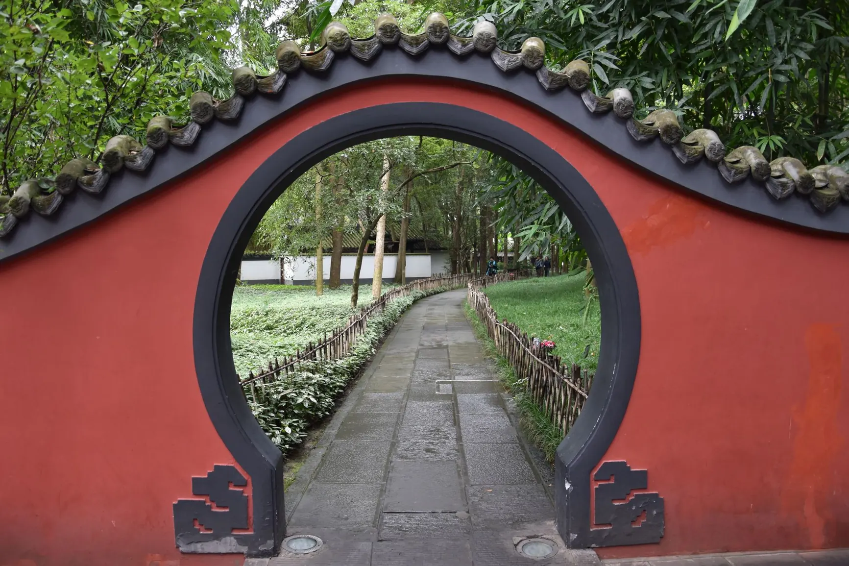 A circular garden doorway in a red wall at Du Fu Thatched Cottage in Chengdu