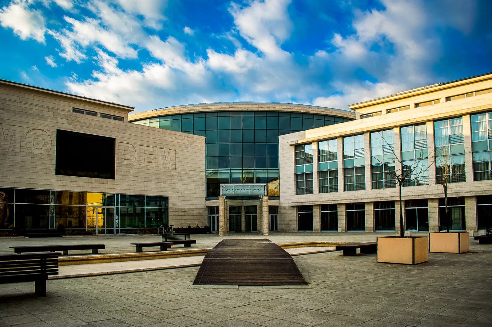MODEM’s curved glass frontage and pale wings facing Baltazár Dezső Square in Debrecen