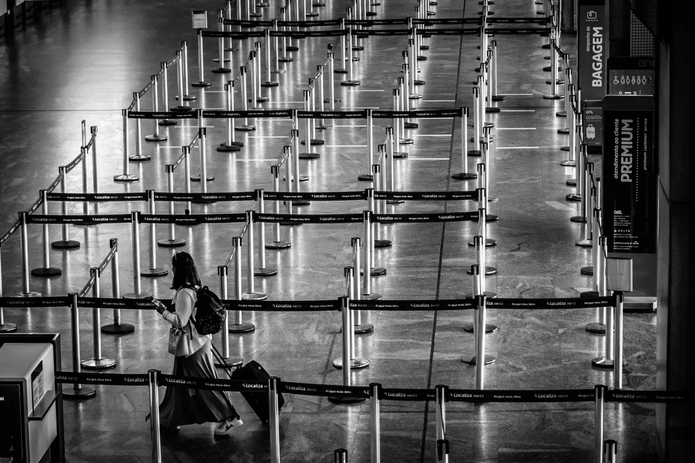 Traveller walking through an airport corridor with a suitcase