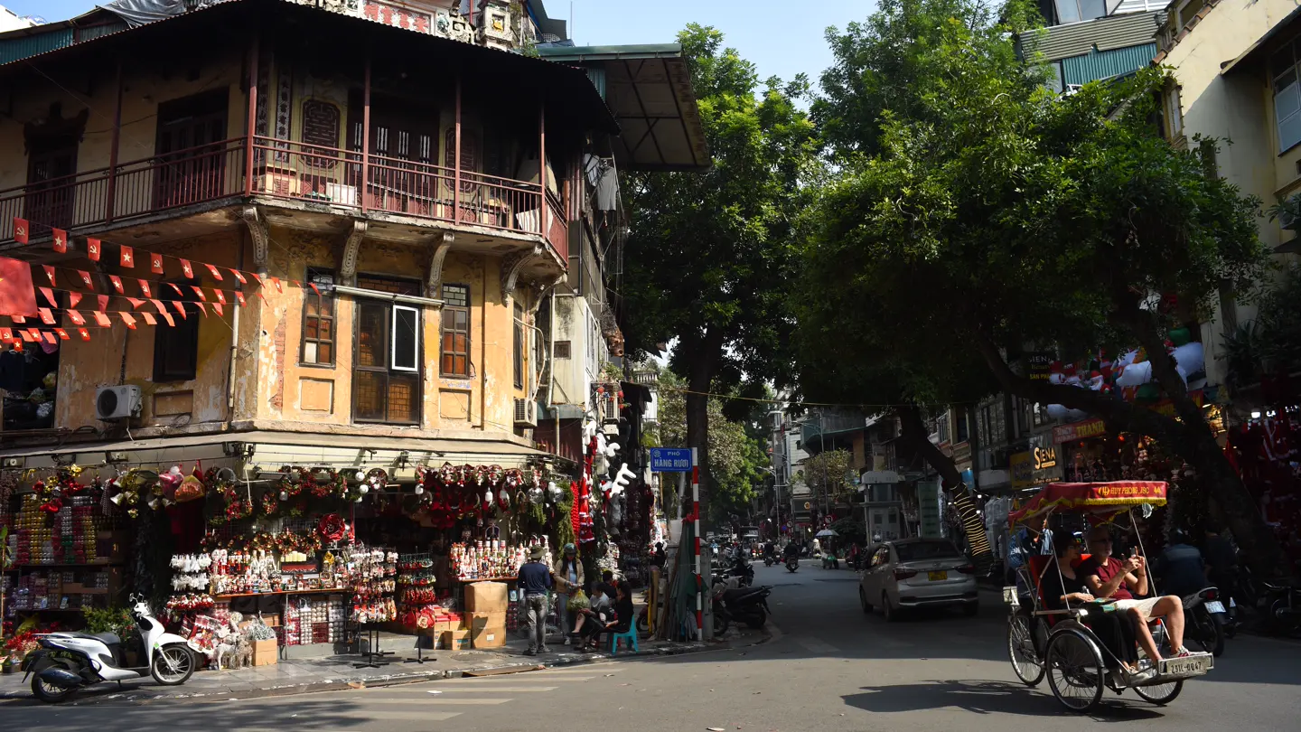 A rickshaw moves through a busy Old Quarter street in Hanoi.