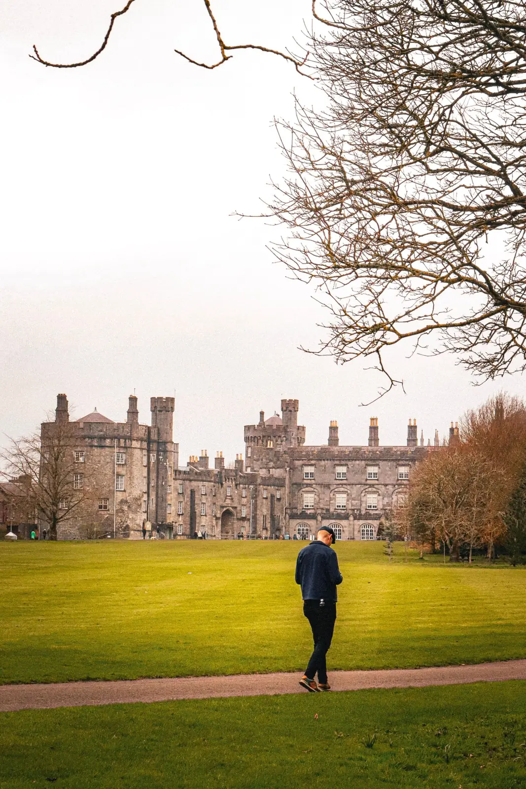 A visitor walking towards Kilkenny Castle