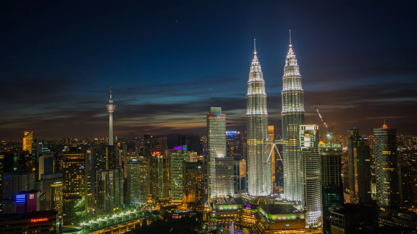 Petronas Twin Towers and the illuminated Kuala Lumpur skyline at night.