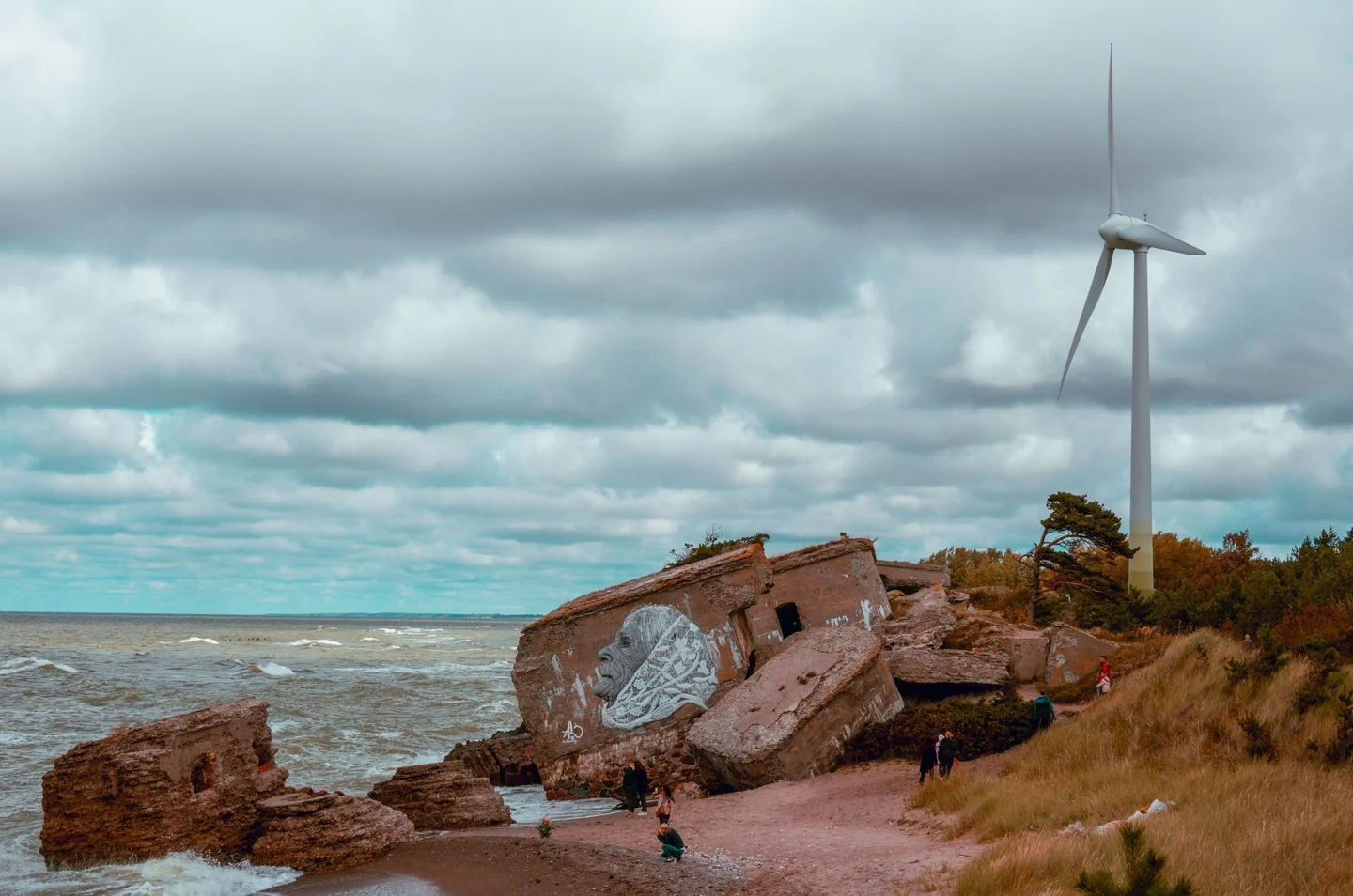 A portrait mural on collapsed Northern Fort concrete beside the Baltic Sea in Liepāja