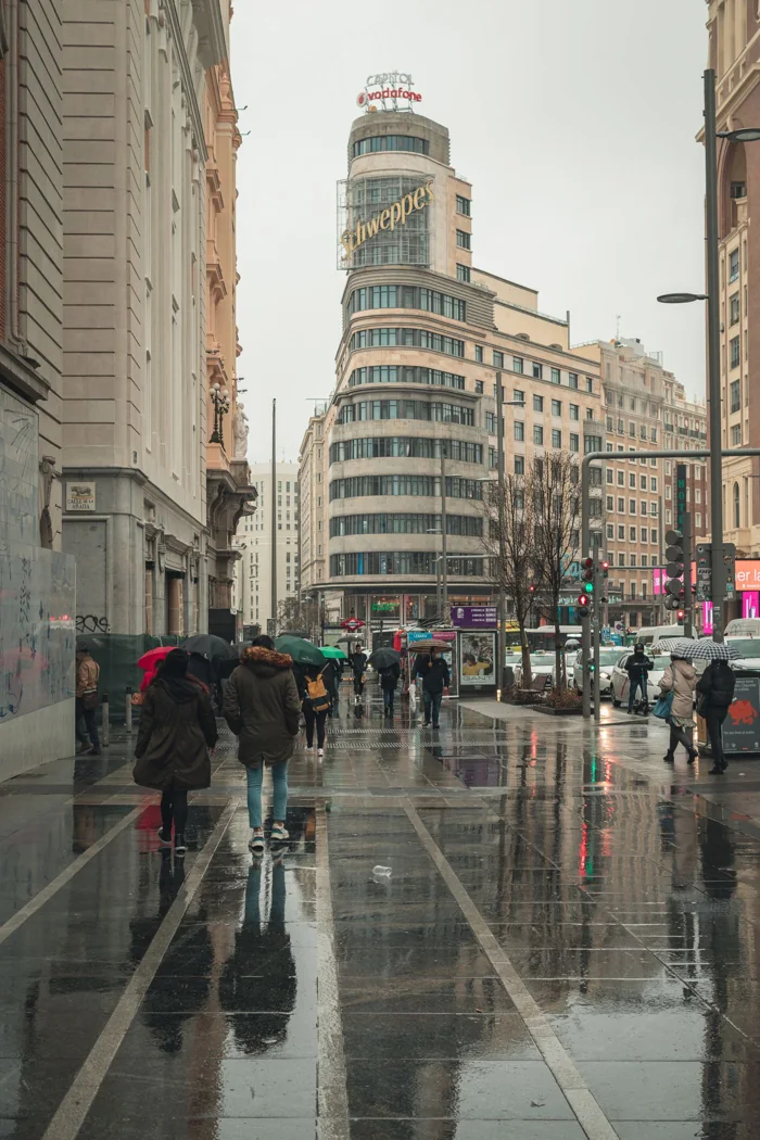Pedestrians on Madrid's Gran Vía after rain