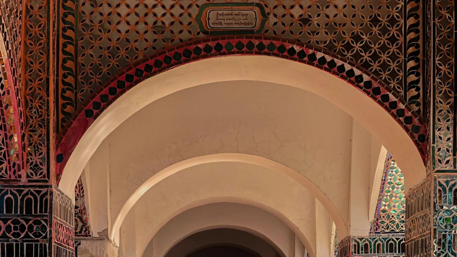 Mirror mosaic and repeated arches in a passage at Sutaungpyei Pagoda on Mandalay Hill.