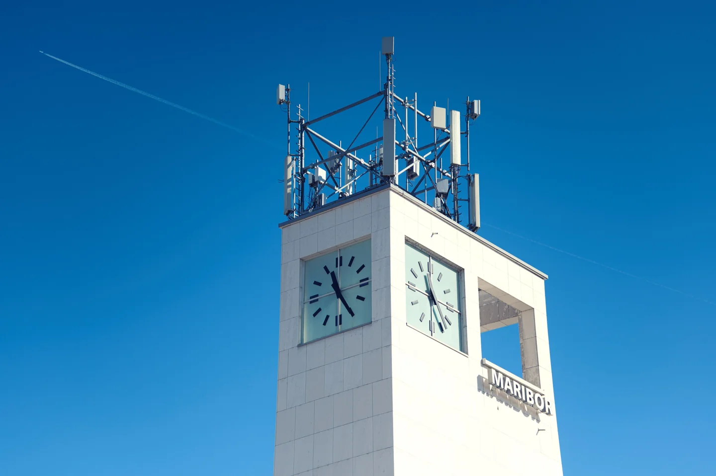 Maribor bus station’s clock tower with the Marprom name against a blue sky