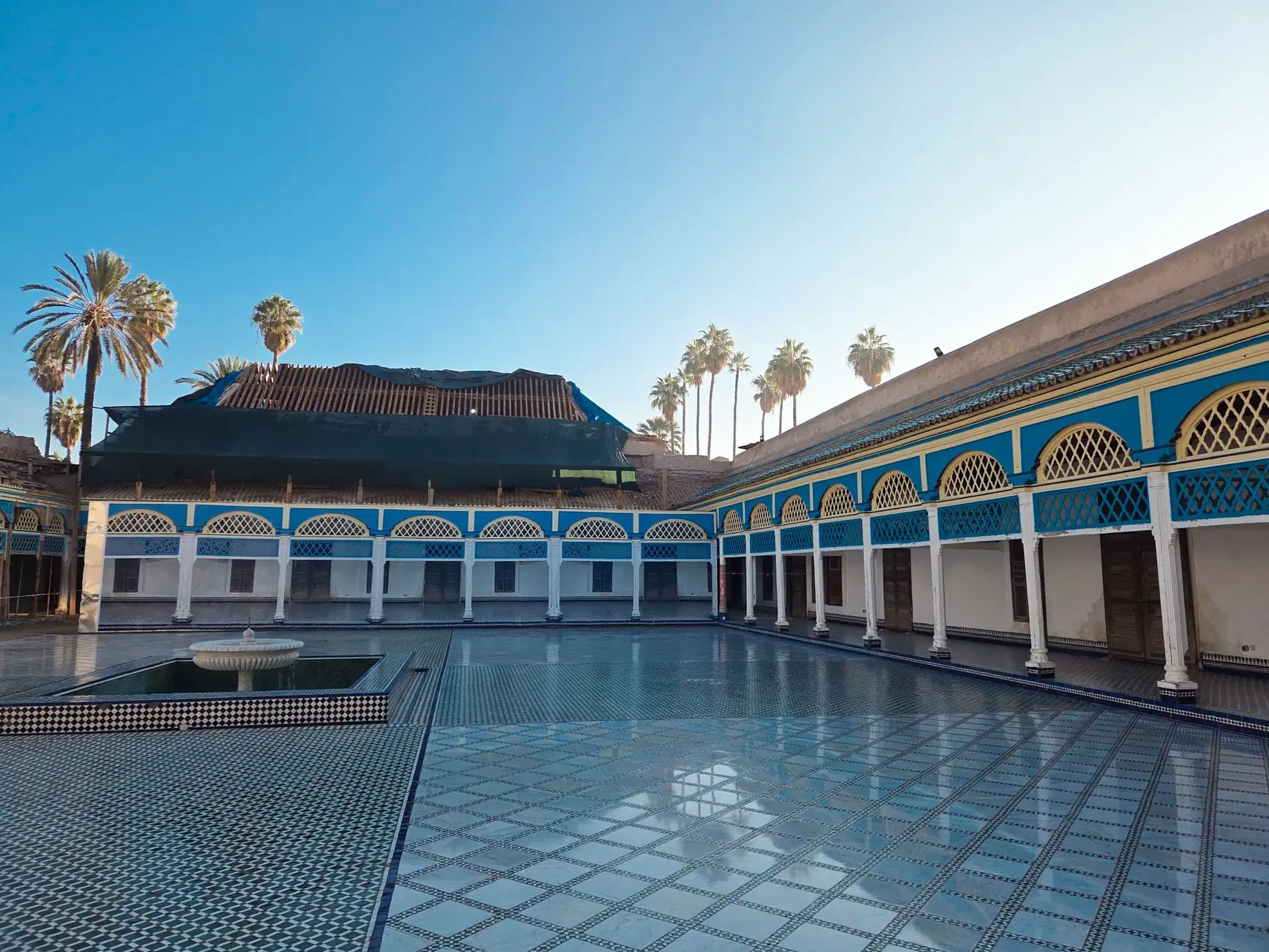 Sunlit courtyard of the Bahia Palace in Marrakech with stunning Moroccan architecture.