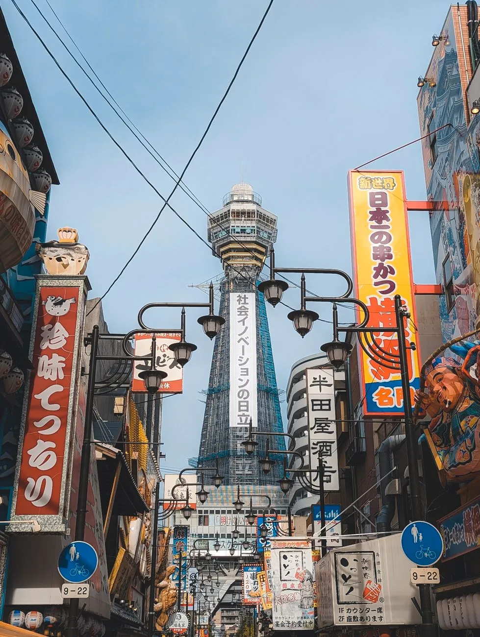 Tsutenkaku’s observation tower framed by Shinsekai’s food signs and street lamps