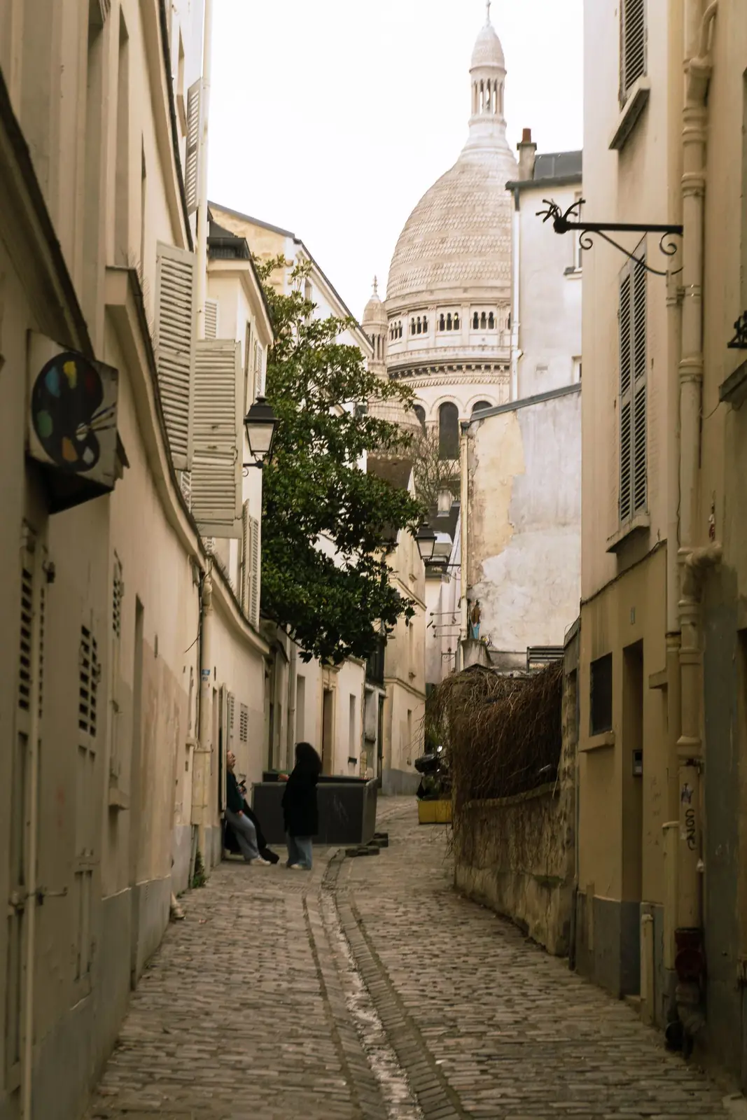 A Montmartre street with Sacré-Cœur above it in Paris