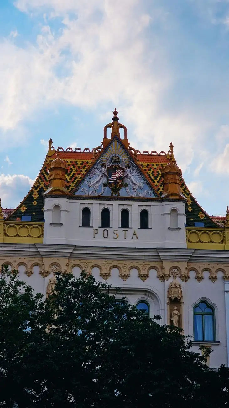 The Postal Palace in Pécs with POSTA lettering and a colourful tiled roof above its ornate façade