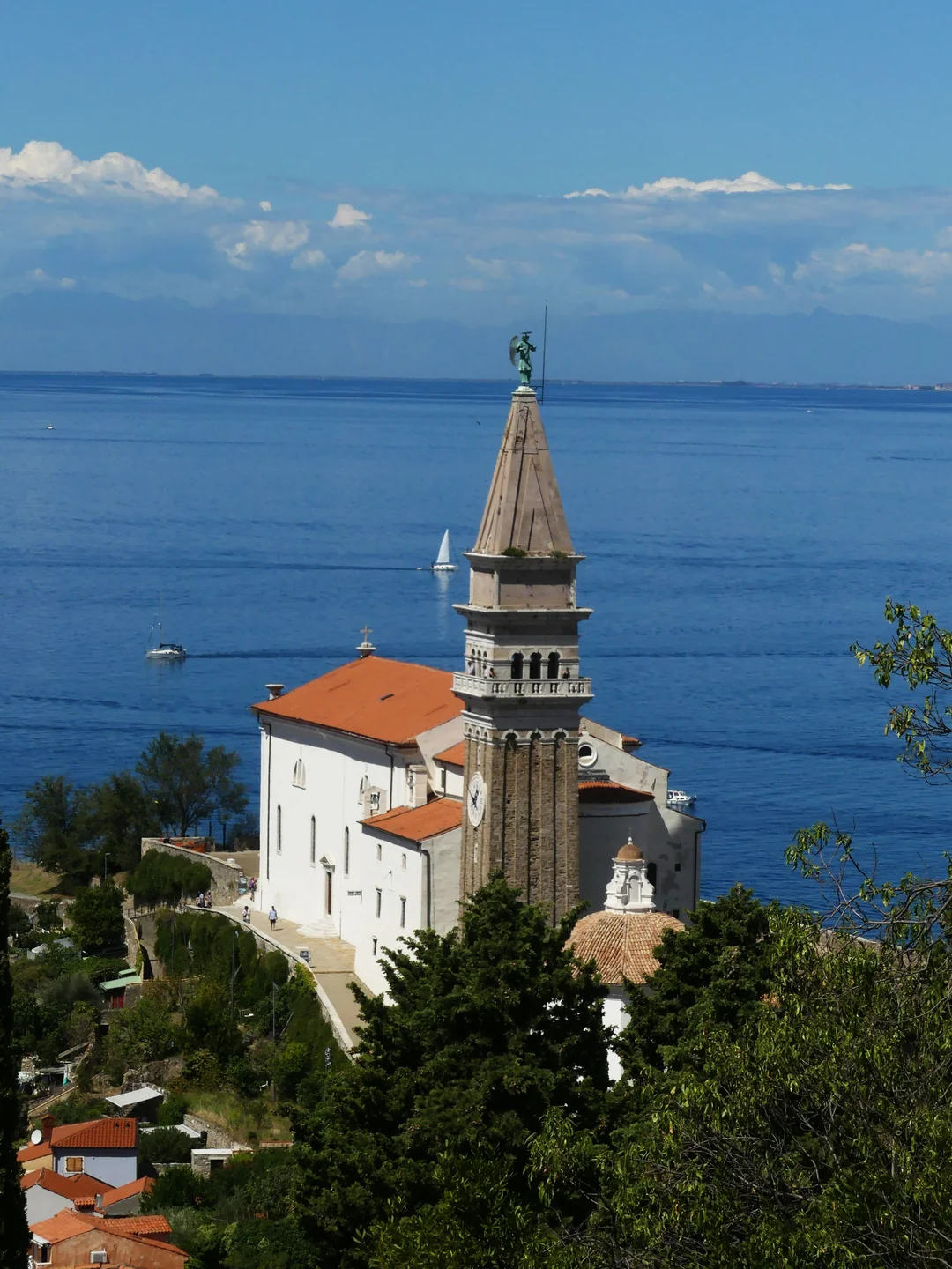 St George’s church and bell tower above the Adriatic shoreline in Piran