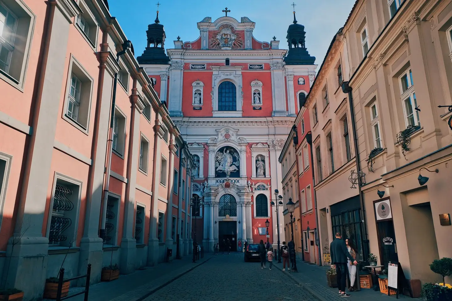 Poznań Fara’s pink-and-white Baroque façade framed by the buildings along Świętosławska