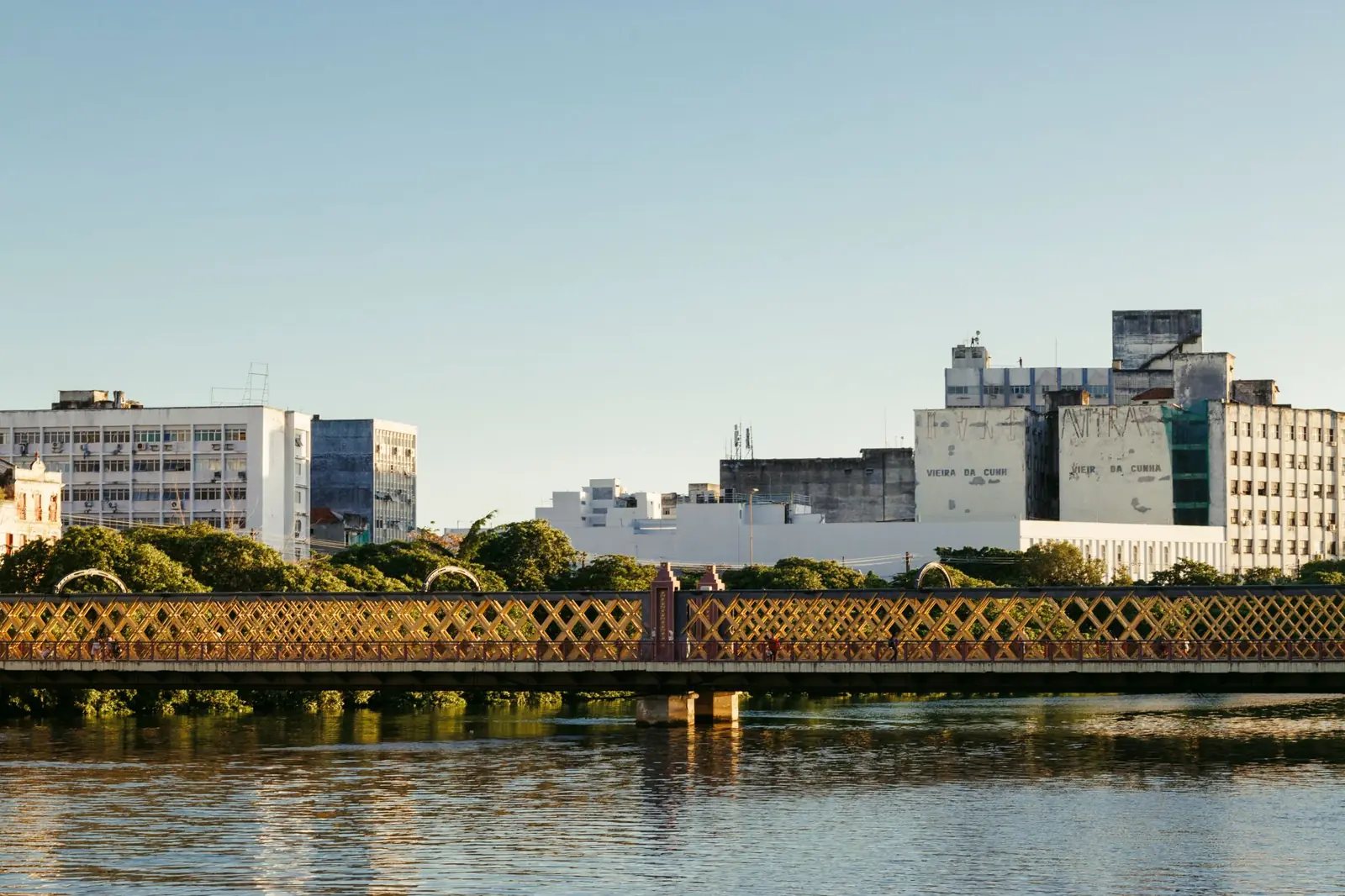 Ponte da Boa Vista’s yellow lattice railings reflected in Recife’s Capibaribe River