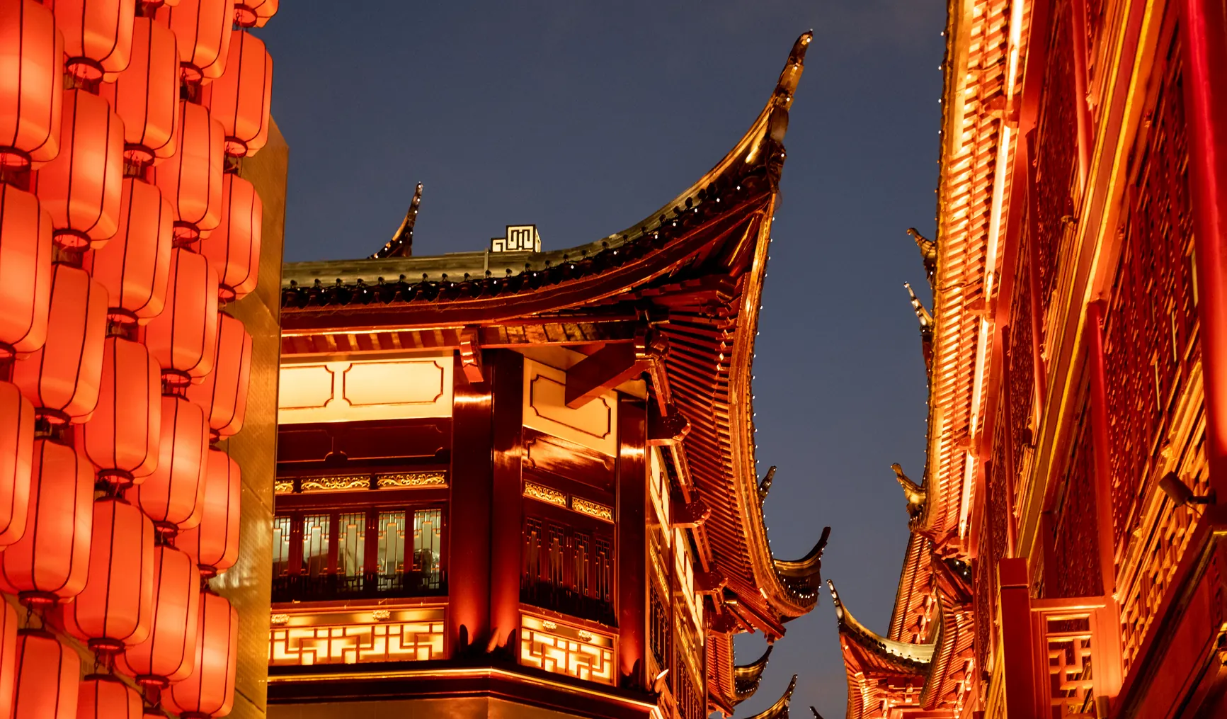 Red lanterns and illuminated traditional roofs in Shanghai’s Yuyuan bazaar area