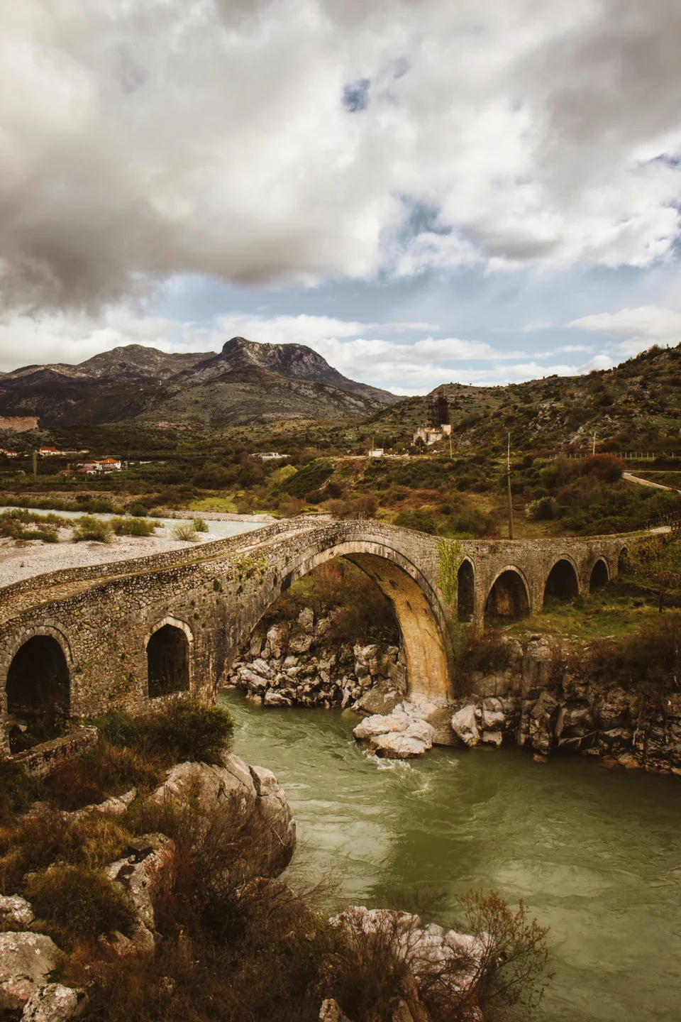 Mesi Bridge’s uneven stone arches spanning the Kir River near Shkodër