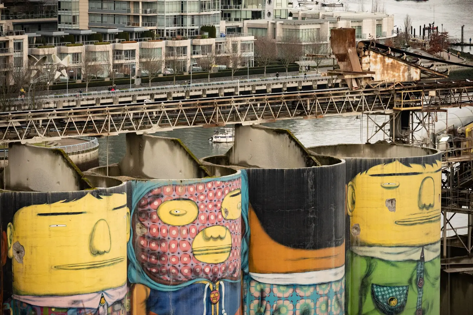 Colourful painted industrial silos on Granville Island with waterfront apartments behind