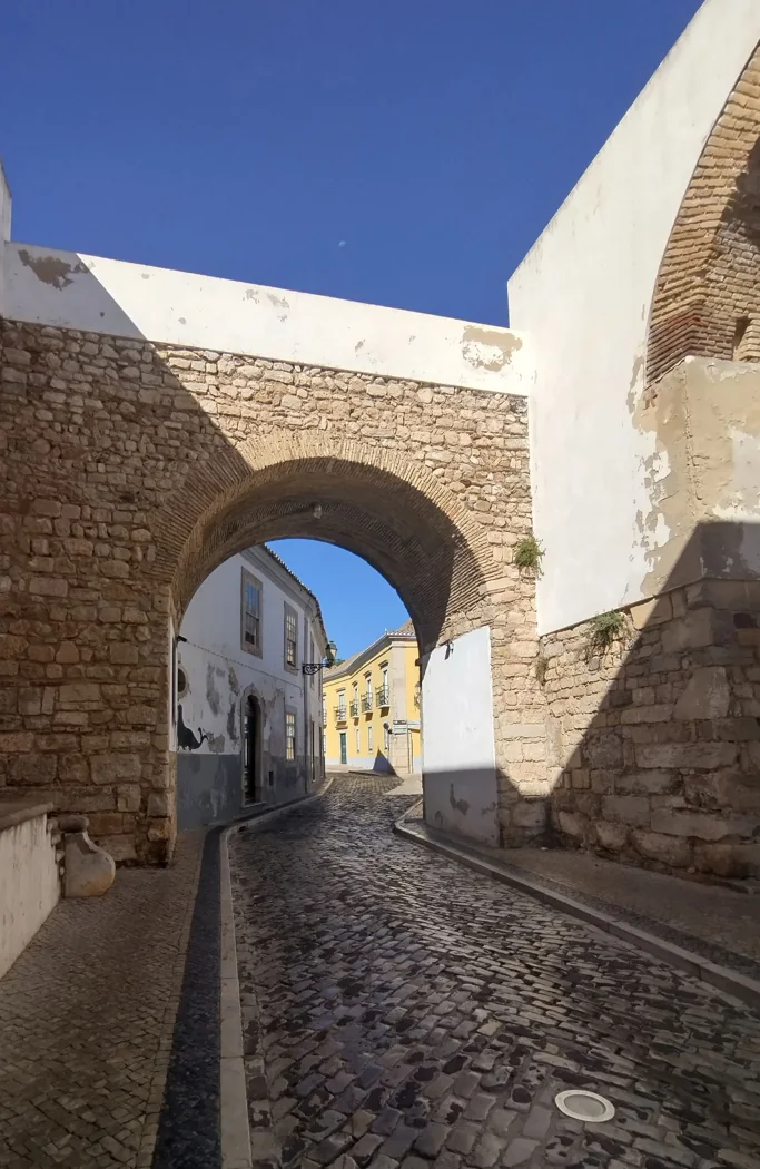 Stone archway and cobbled street in Faro’s old town