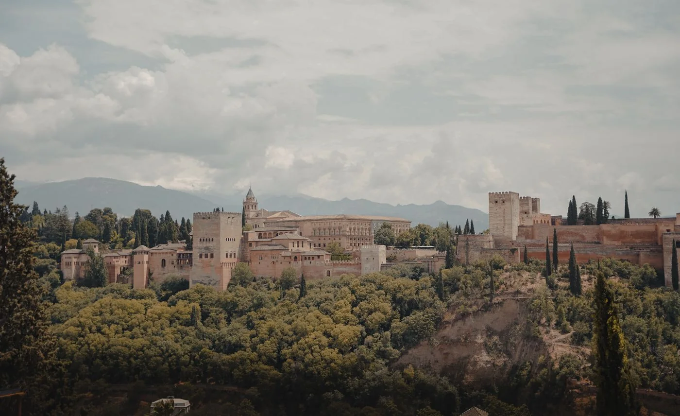 The Alhambra above green slopes in Granada