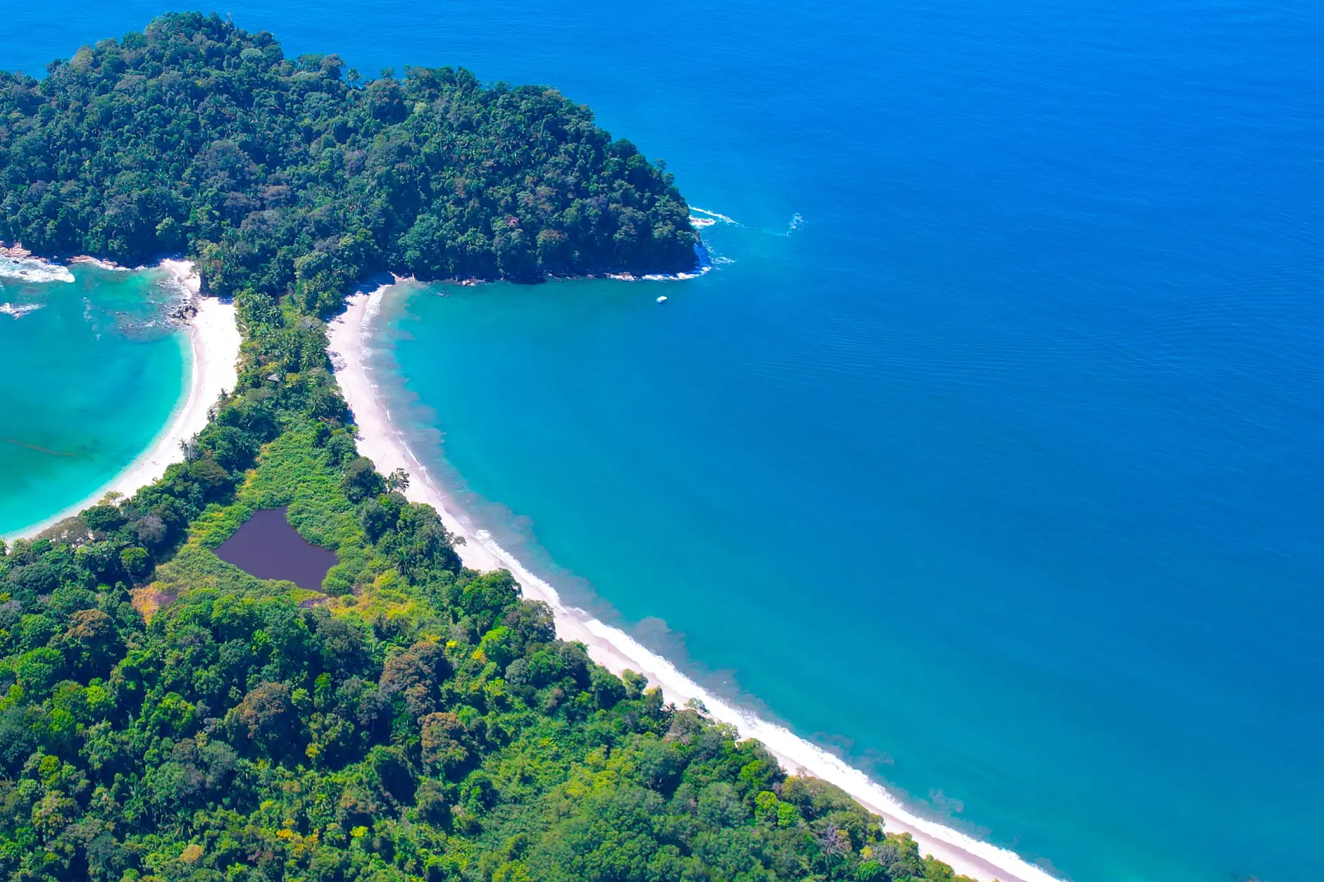 Forested Punta Catedral and the sandy neck between two beaches in Manuel Antonio National Park near Quepos
