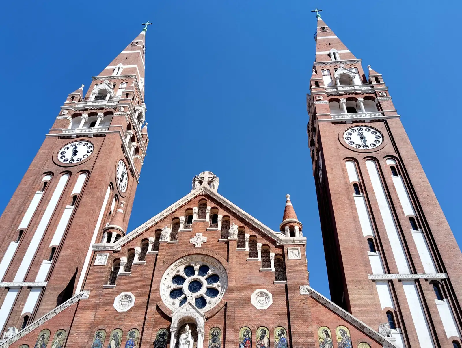 Szeged’s red-brick Votive Church with twin clock towers and a central rose window