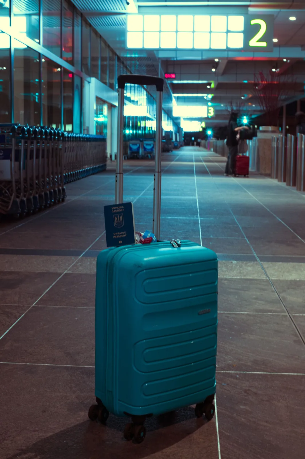 Blue suitcase and passport in an airport terminal